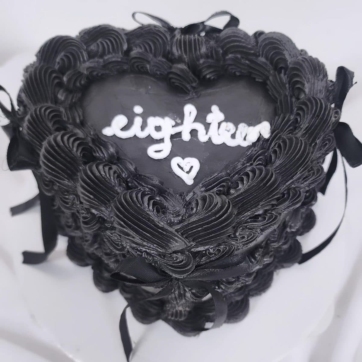 Bento cake e zezë në formë zemre me mbishkrimin eighteen për 18-vjetorin