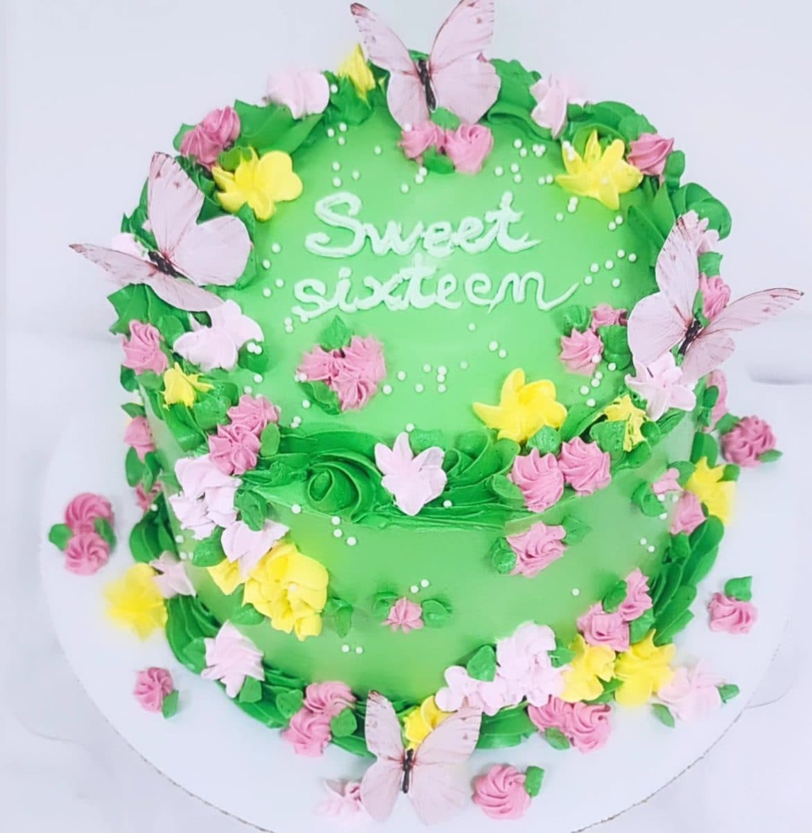 Tortë e gjelbër me lule dhe flutura me mbishkrimin Sweet Sixteen