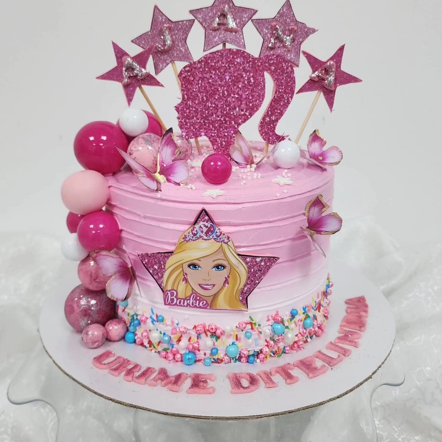 Torta Barbie rozë me dekorime yjesh dhe figura Barbie
