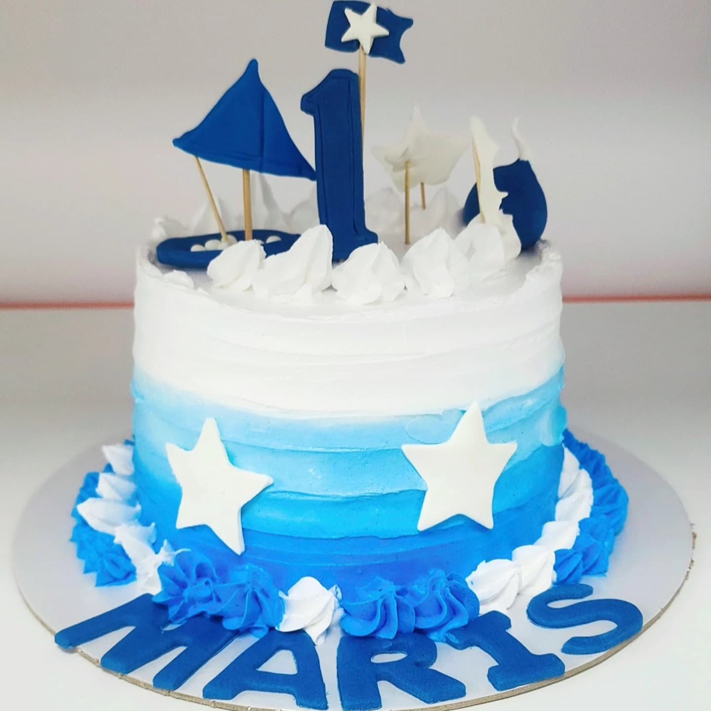 Tortë blu me yje për 1-vjetor, dekoruar me numrin 1 dhe anije