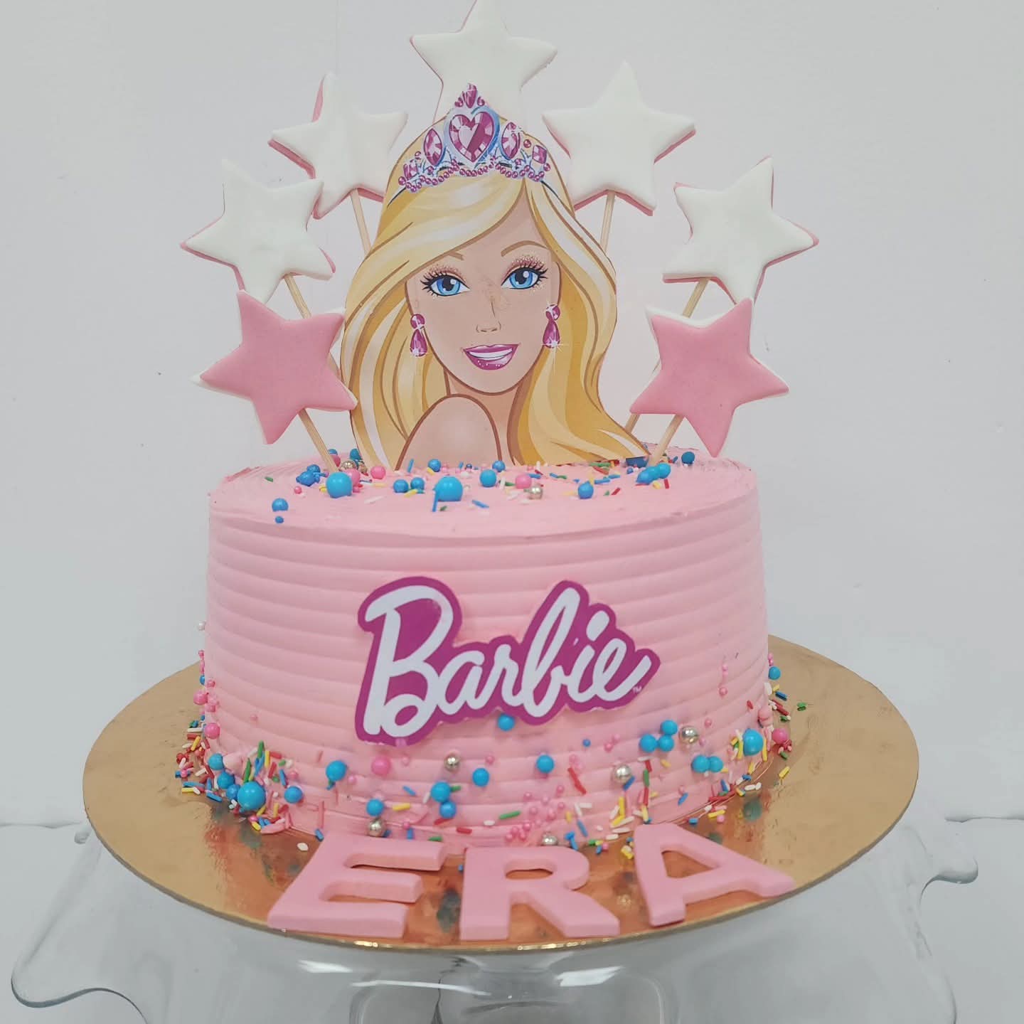 Torte rozë me dekorime yjesh dhe figurë Barbie
