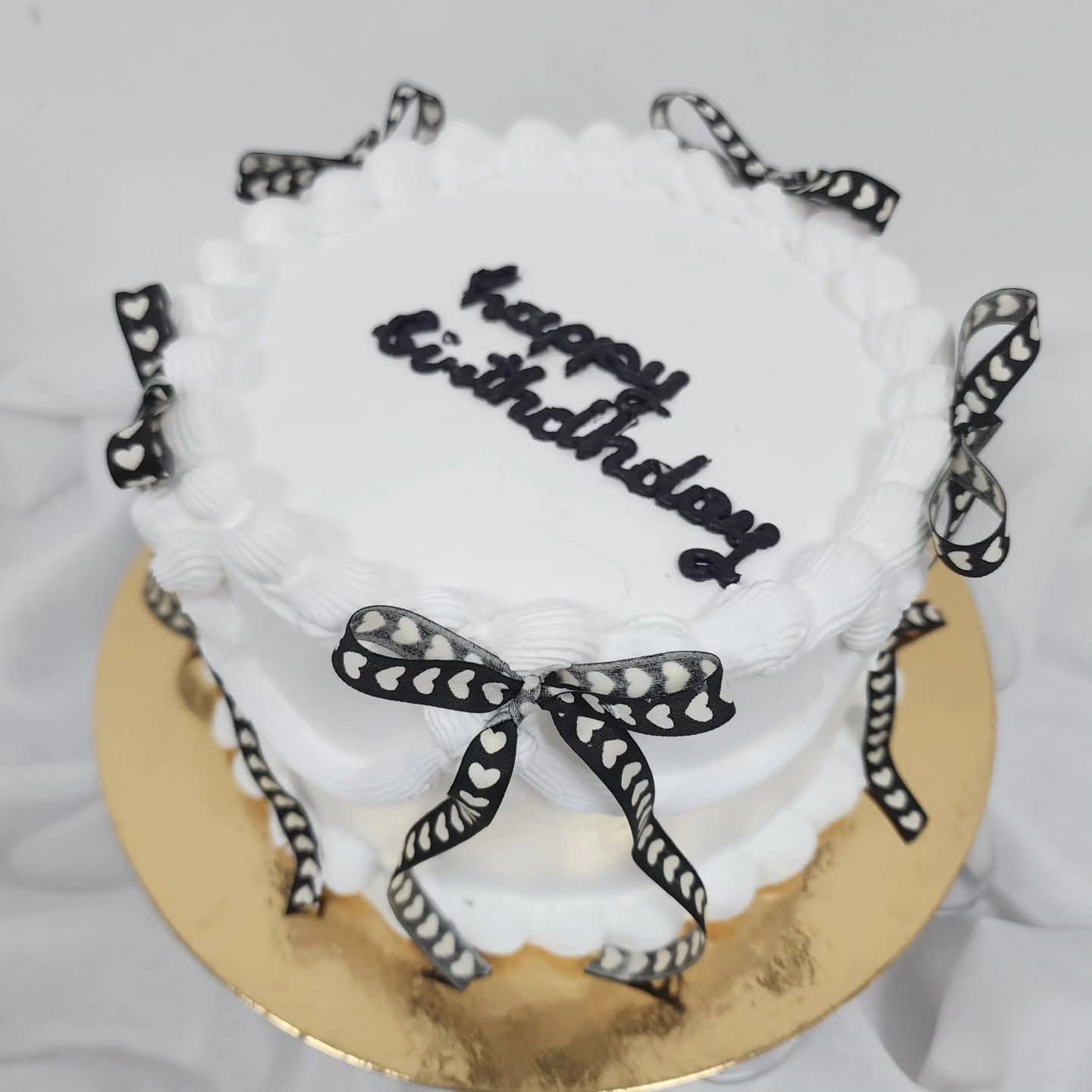 Tortë Ditëlindje me Fjongo Zemrash - Torte për Ditëlindje | Tortelinda Tortë e bardhë për ditëlindje me fjongo të zeza dhe zemra