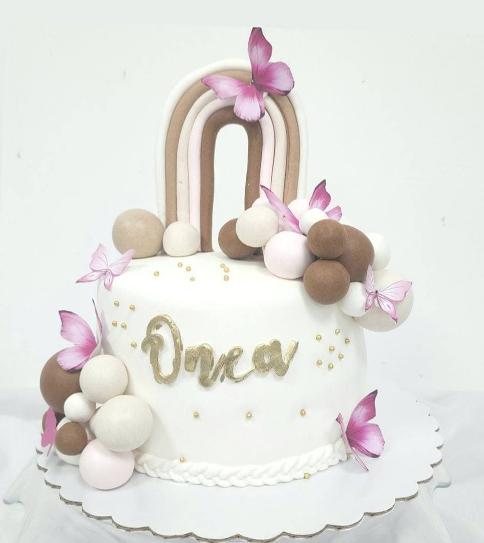 Tortë e bardhë me flutura rozë dhe dekorime elegante