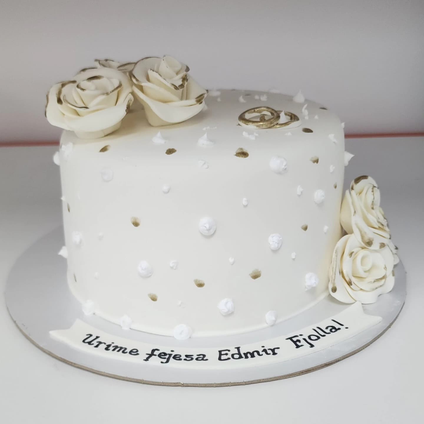 Tortë fejese e bardhë me lule dhe unaza