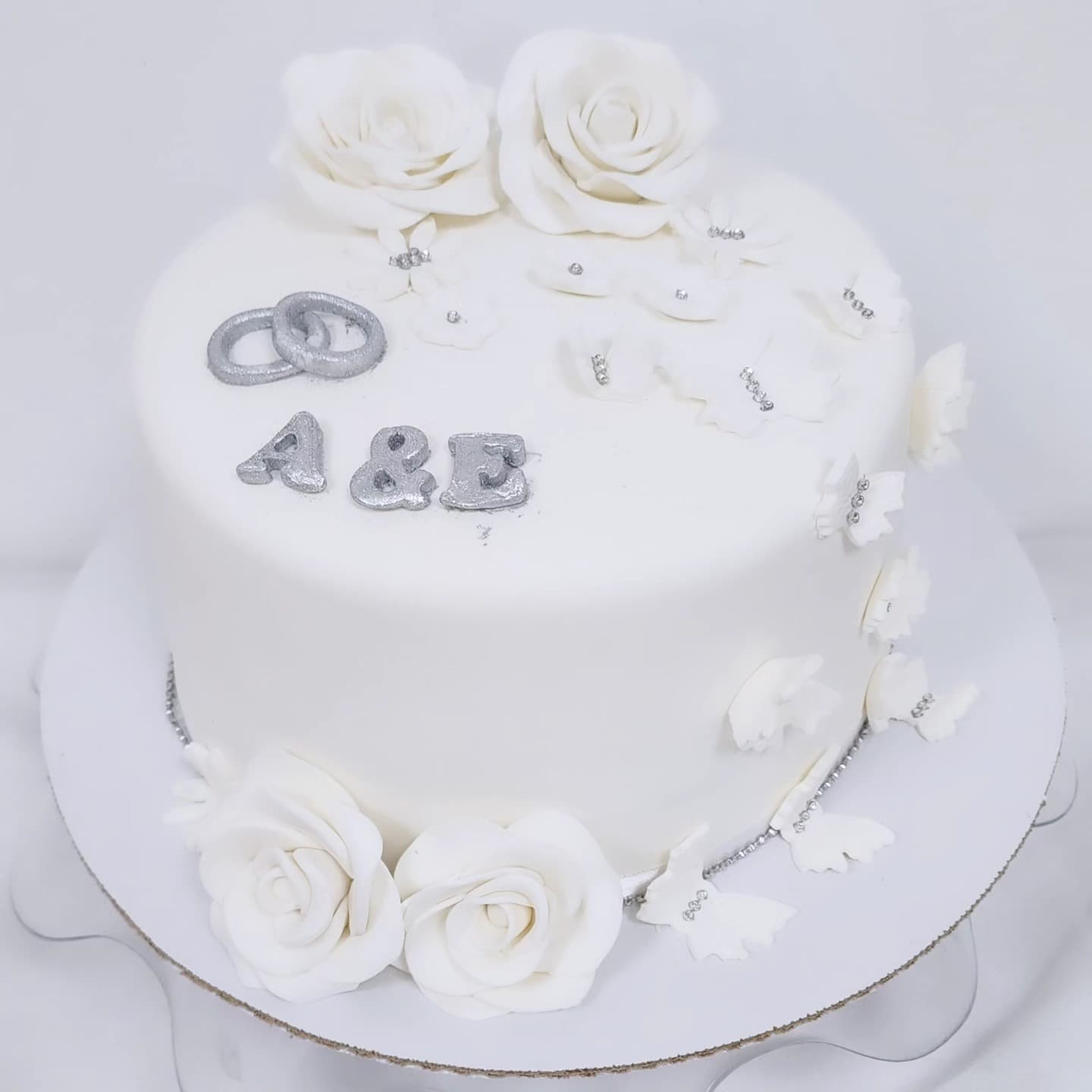 Torte martese e bardhë me trëndafila dhe detaje argjendi