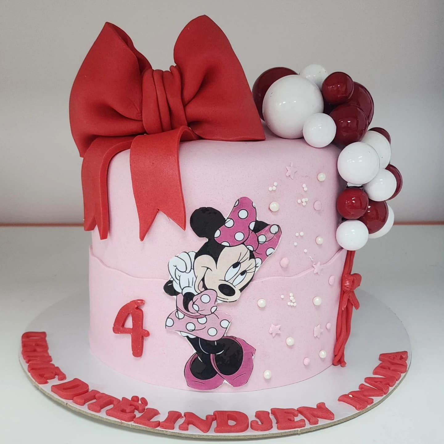 Torte Minnie Mouse me Fjongo - Torte për Fëmijë | Tortelinda Torte Minnie Mouse me fjongo të kuqe dhe dekorime rozë
