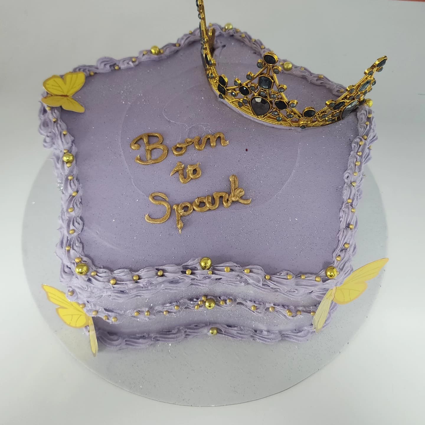 Torte Princeshë me Kurorë dhe Flutura - Torte për Vajza | Tortelinda Torte katrore vjollcë me kurorë ari dhe flutura të verdha