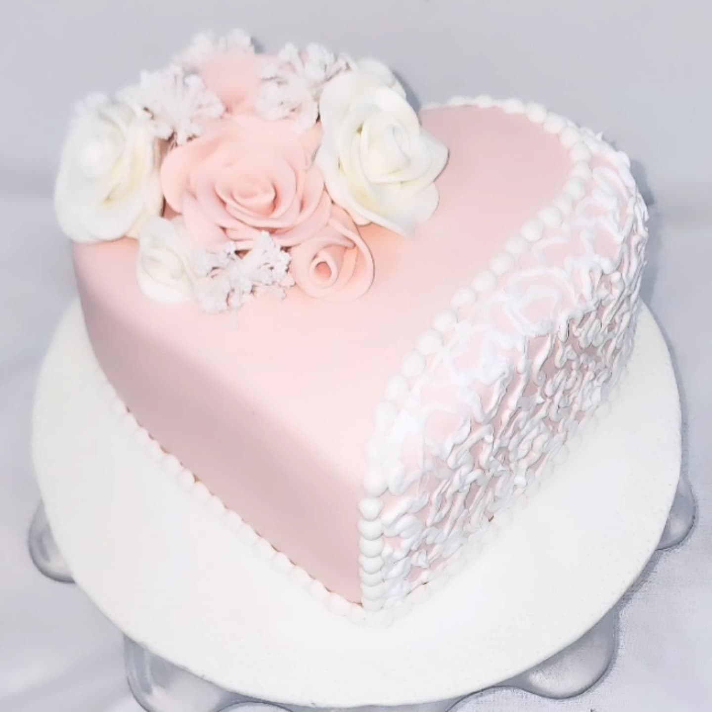 Torte në formë zemre me trëndafila rozë dhe të bardhë